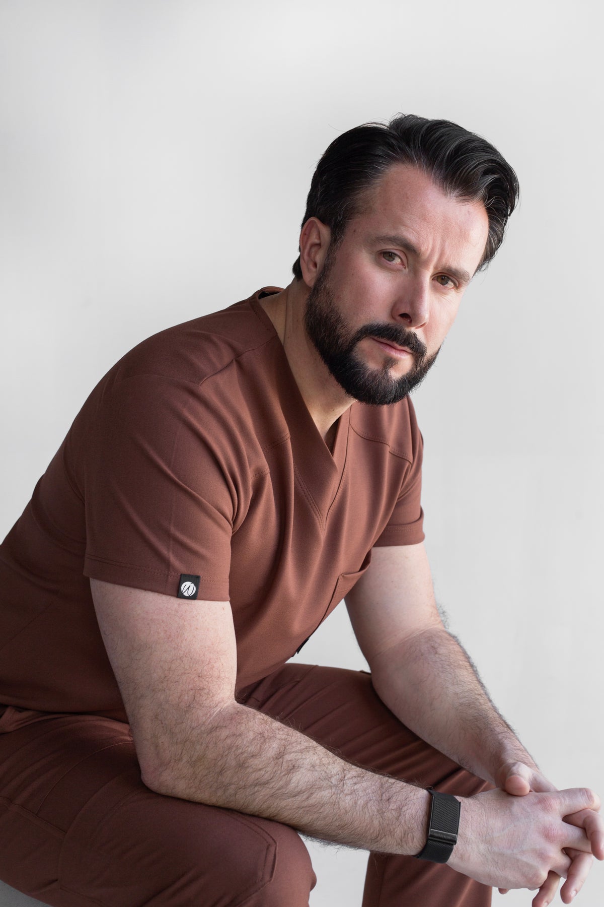 Man wearing Fresh Cocoa Scrub Top in a seated position showing the comfortable fit