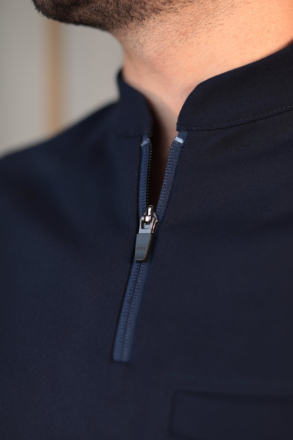 Close-up of Harry Navy Scrub Top showing the high collar and zipper neckline