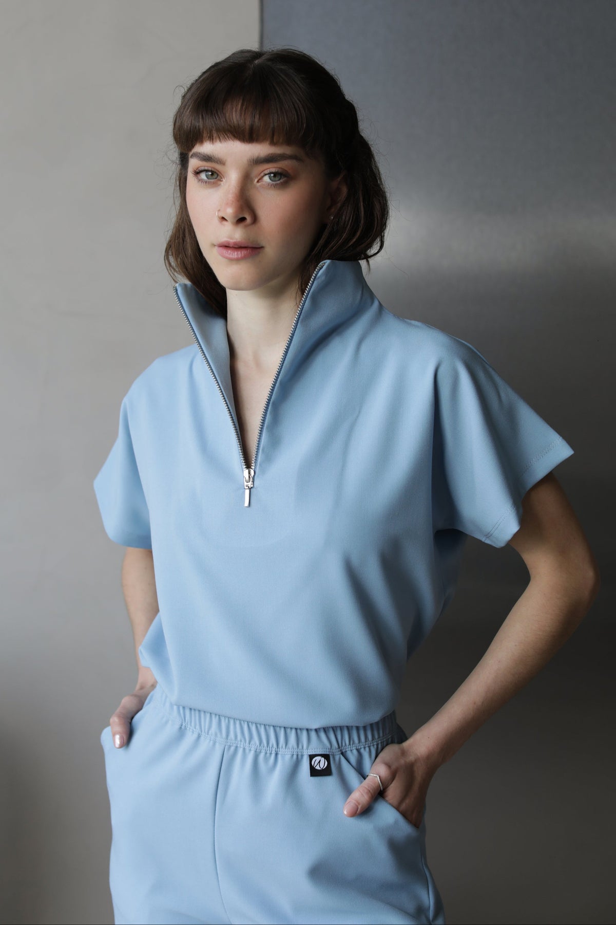 Woman wearing Victory Dream Blue Scrub Top by Work & Chill