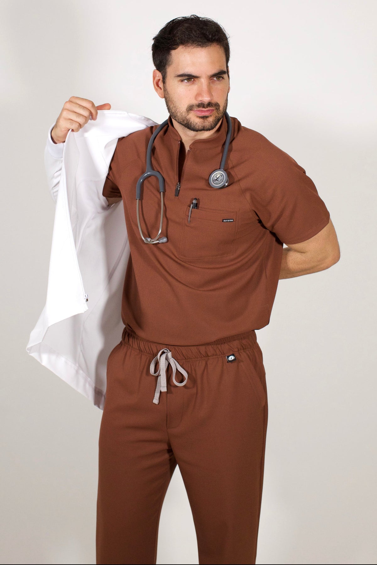 Man wearing Cocoa scrubs styled with the Men’s White Work Coat