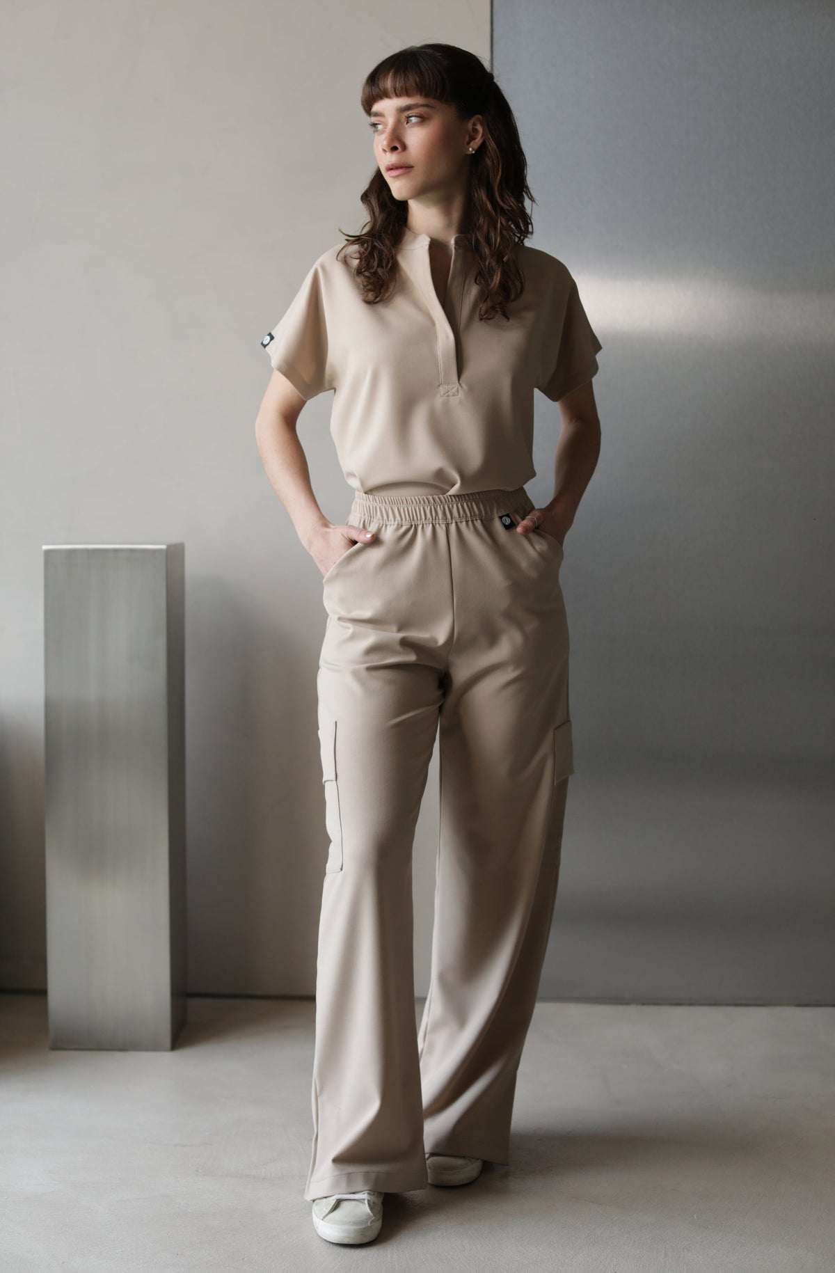 Model wearing Glam Natural Scrub Top with matching scrub pants