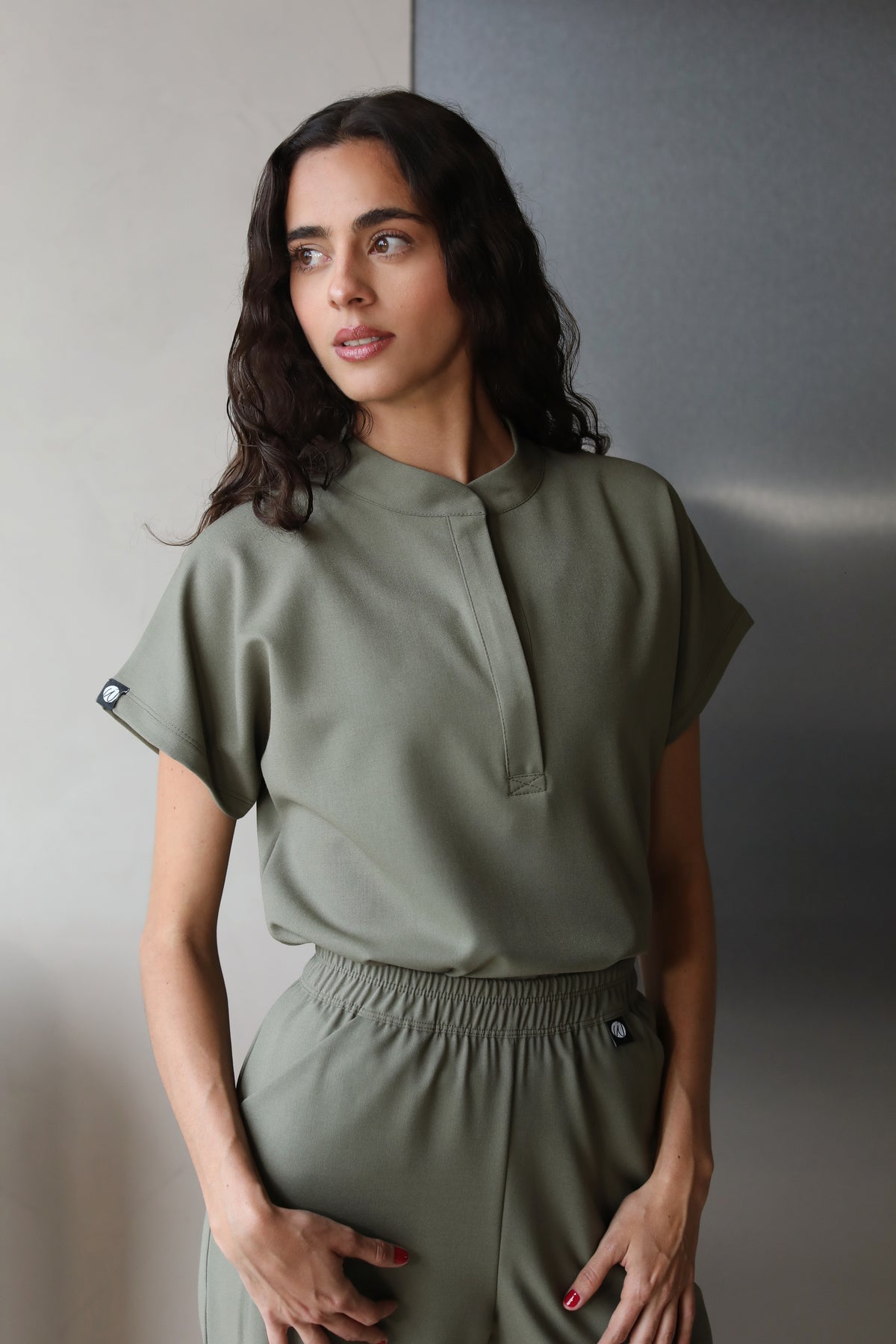 Woman wearing Glam Olive Scrub Top by Work & Chill