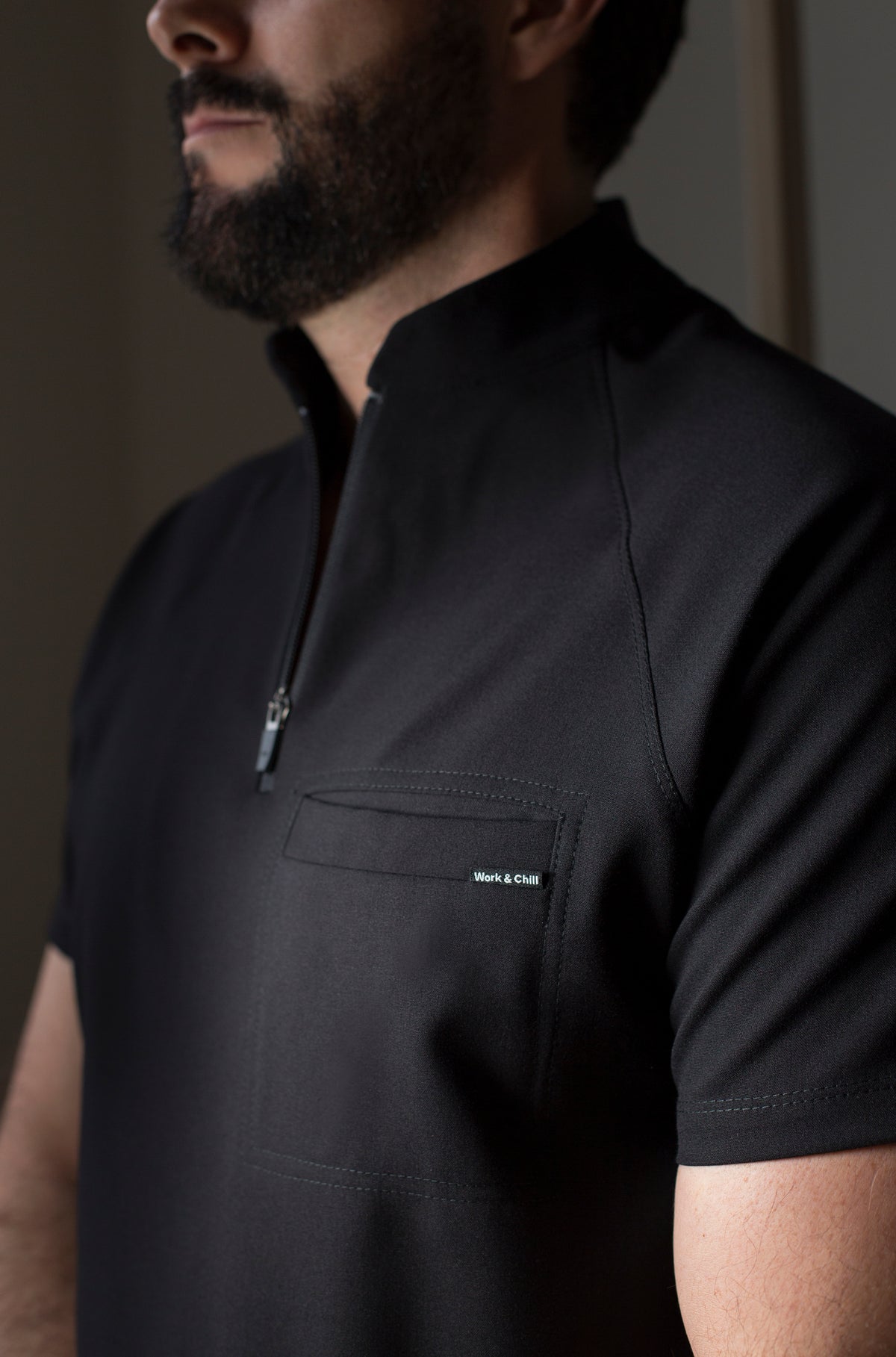Close-up of Harry Black Scrub Top showing the high collar and zipper neckline