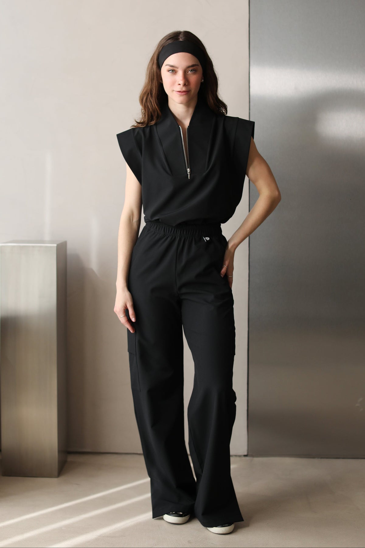 Full-body front view of a woman wearing Kate Black W&C Shield™ scrub pants with the matching Kate Black scrub top.