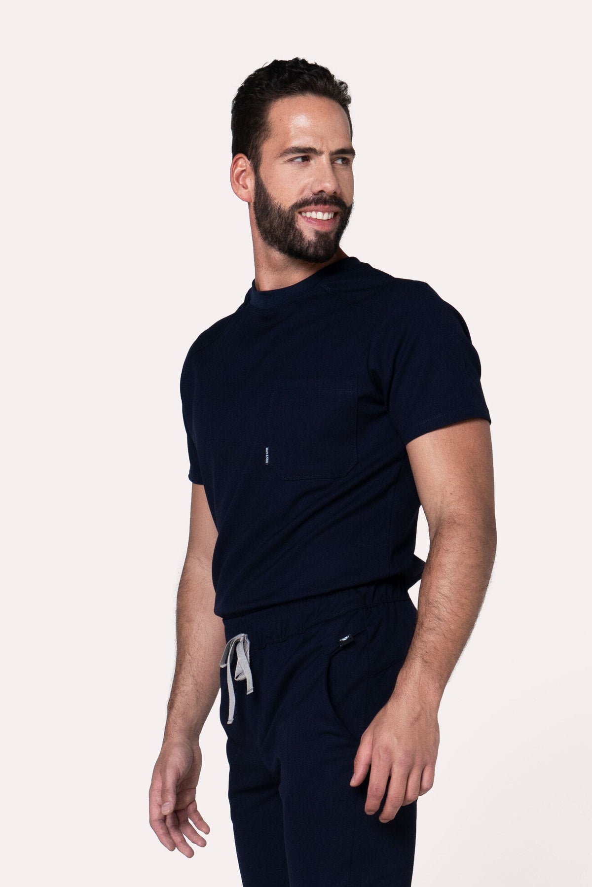 Three-quarter view of Sport Navy Scrub Top showing the relaxed athletic fit
