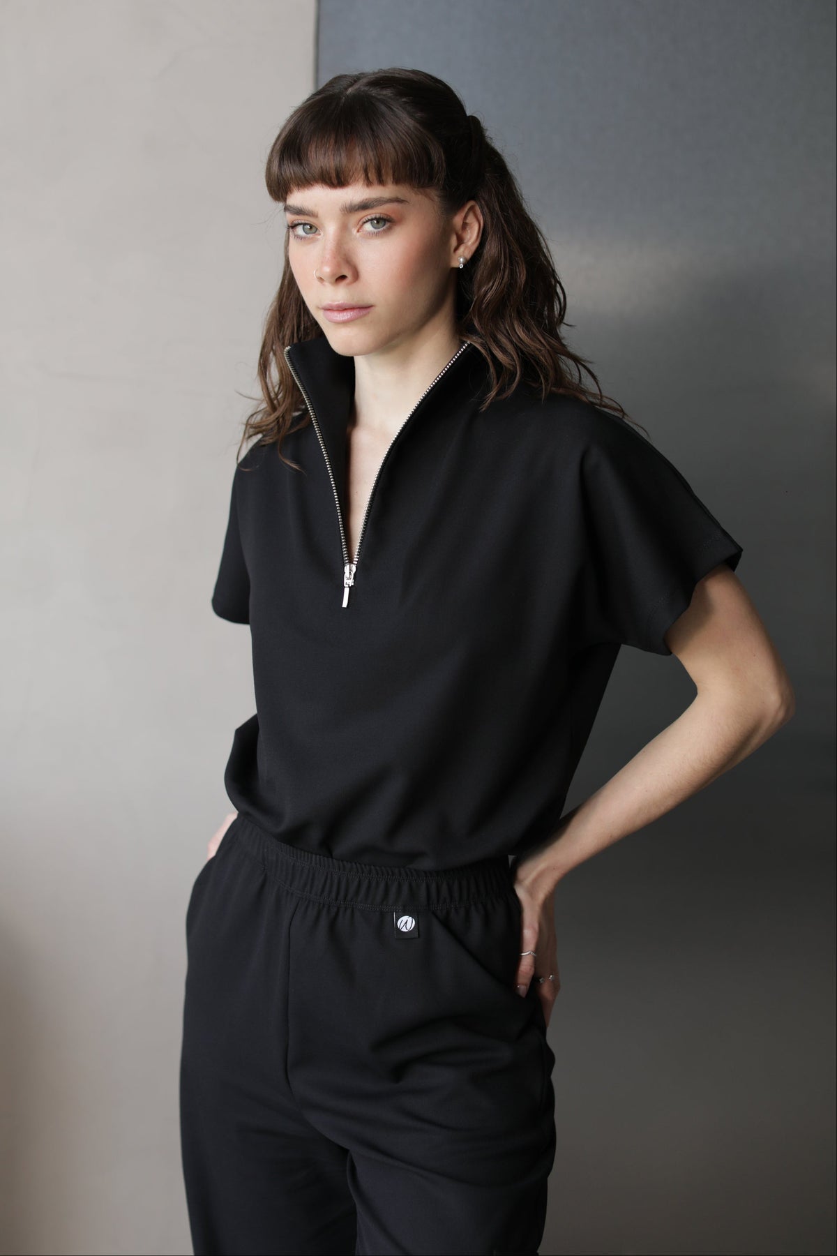 Woman wearing Victory Black Scrub Top by Work & Chill