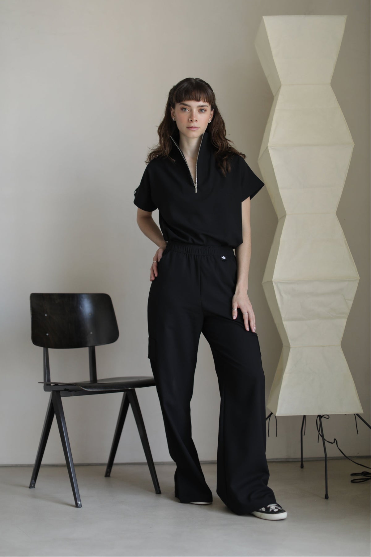 Model wearing Victory Black Scrub Top with matching scrub pants