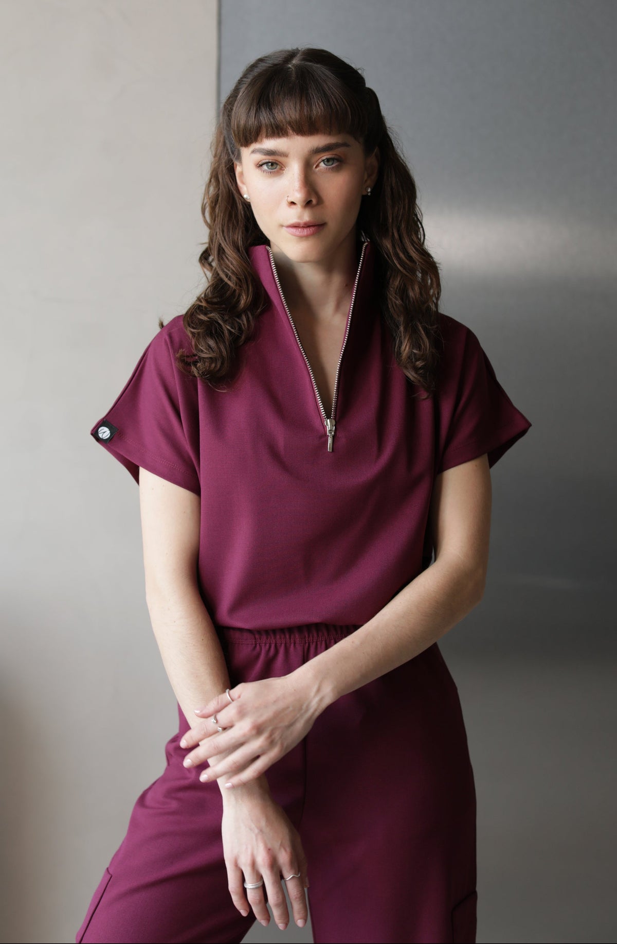 Woman wearing Victory Burgundy Scrub Top by Work & Chill