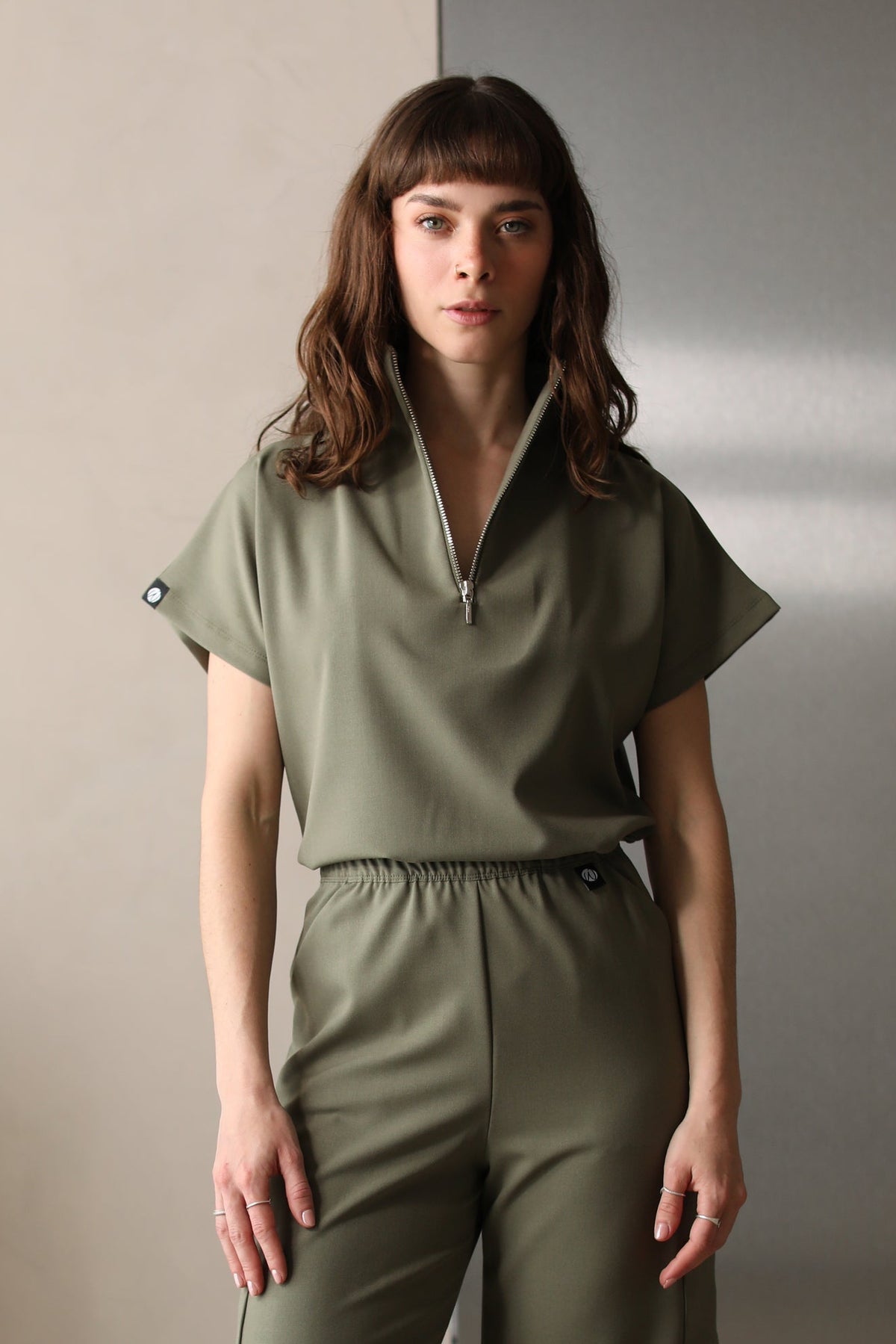 Woman wearing Victory Olive Scrub Top by Work & Chill